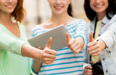 women with tablet pc showing thumbs up