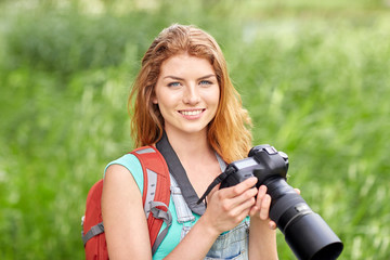 happy woman with backpack and camera outdoors