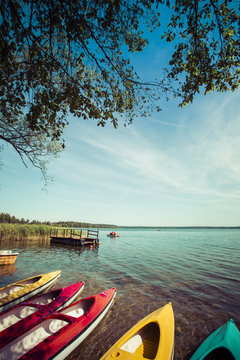 Colorful kayaks moored on lakeshore, Goldopiwo Lake, Mazury, Pol