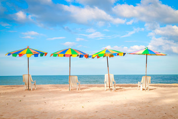Beach chairs with colorful umbrella at the beach with blue-sky background on summer.