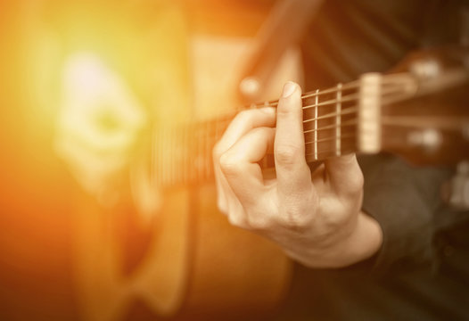 Young man play on the acoustic guitar