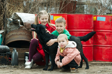 children play at dump with dog