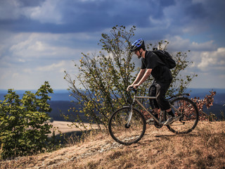 Fototapeta na wymiar Biking in the Franconian Hills in Northern Bavaria. Young man on