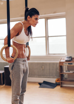 Sports woman working out with gymnastic ring