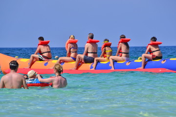 gruppo di persone su un gommone a forma di banana in mare aperto
