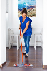 Portrait Of Young Woman Mopping Floor At Home . Cleaning Sevice