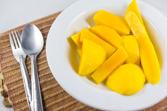 mango on dish with spoon and fork