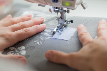 close woman hands sewing on sewing machine
