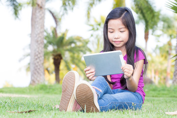 Fototapeta premium Asian little girl with a Tablet