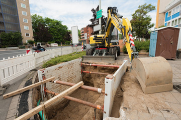 Bagger, Baugrube und Verbauplatte - Baustelle mit Weitwinkel