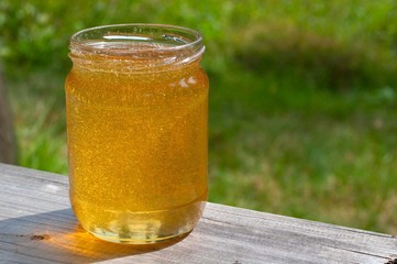 Jar of honey on a wooden table.