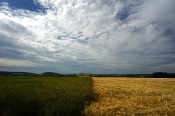 Obraz premium Kontraste der Felder mit Wolkenspiel