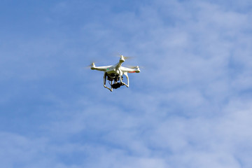 Fototapeta na wymiar Drone with camera hovering in the sky