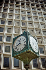 Fototapeta na wymiar large public clock in front of skyscraper windows