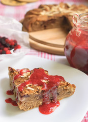 Piece of homemade cake with berry sauce on plate
