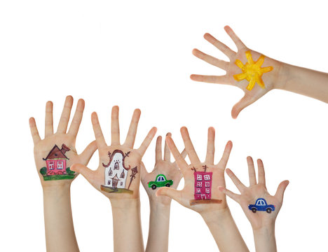 Houses, car and trees painted on children hands. Hands raised up