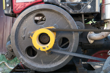 Engine of used mini tractor: black pulley and belt.