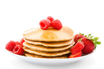 Pancakes with berries on a plate over white background.