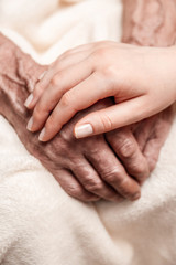 Hands of the old man and a young woman. close up. toning
