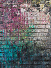 Dirty brick wall painted with spots of paint colors