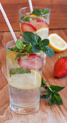 homemade lemonade with mint and strawberries on a wooden