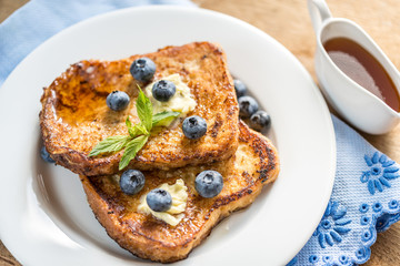 French toasts with fresh blueberries and maple syrup