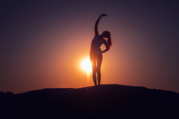 Silhouette fitness girl at sunset