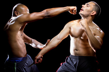 Martial arts instructor demonstrating self defense against a knife attack