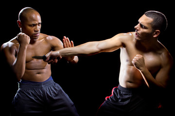 Martial arts instructor demonstrating self defense against a knife attack