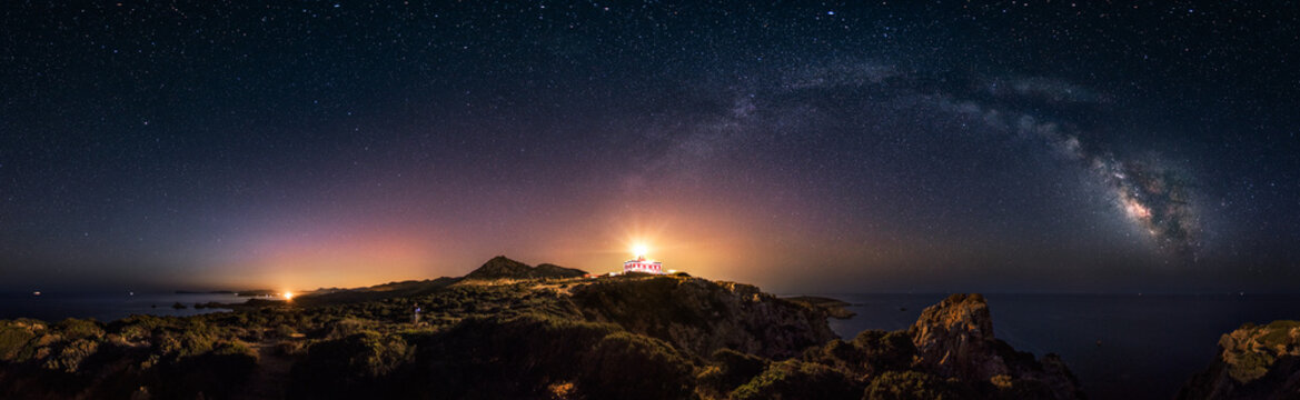 360° rectilinear panoramic view of starry night with milky way arc and lighthouse of Capo Spartivento 