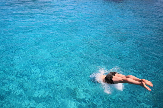 man diving into blue waters