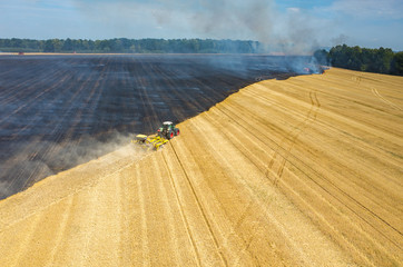 Tractor harrowing the field in fire
