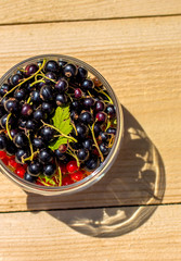 Red and black currants in a glass jar top view
