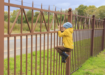 escapee. boy climbing a fence trying to escape