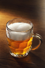 Mug of beer on wooden table