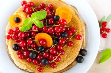Pancakes with berries and fruits: apricot, red, blackcurrant