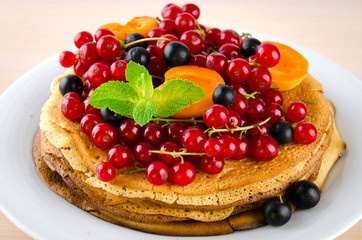 Pancakes with berries and fruits: apricot, red, blackcurrant