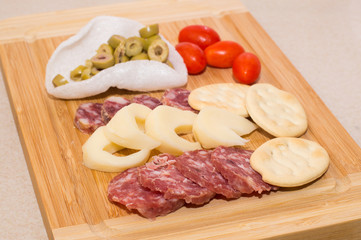 Antipasto su tagliere, olive salame, pomodoro pachino e crackers