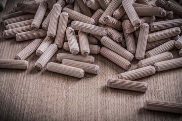 Variety of cylinder wooden dowels on wood board construction con