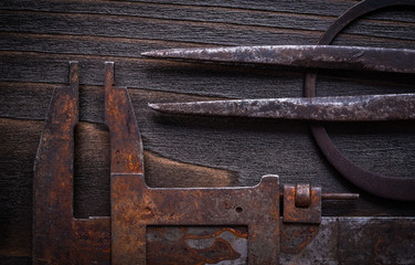 Set of rusted vernier calipers on vintage wooden background