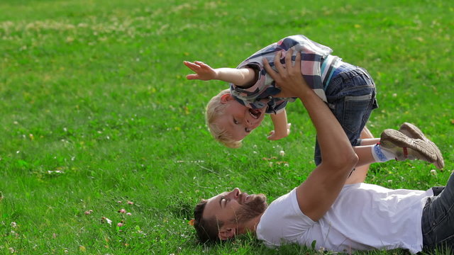 Father and son playing on the grass in park