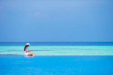 Fototapeta na wymiar Young woman reading book during tropical white beach