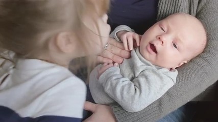 Newborn boy kissed by toddler sister