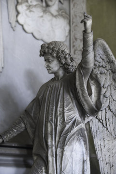 The angel. The statue of a beautiful angel pointing his finger to the sky.