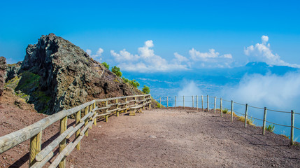 wide path is leading on the top of mount vesuvius volcano near italian naples and it offers great view of volcanos interior as well as of surrounding bay of naples. - obrazy, fototapety, plakaty