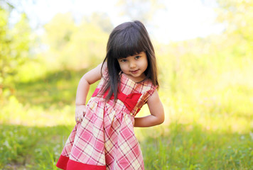 Portrait of little girl child wearing a dress outdoors in summer