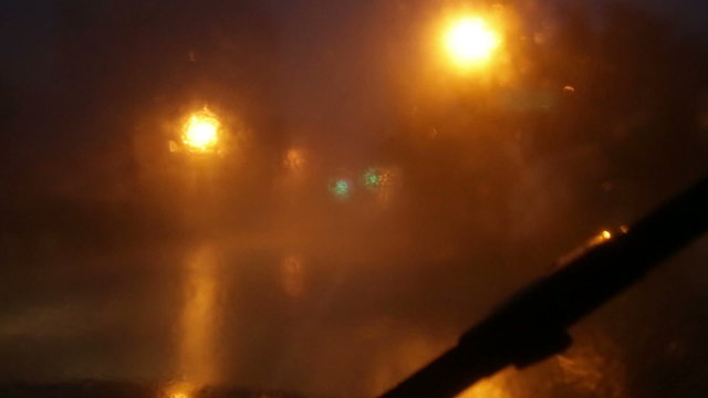 Heavy rain against windshield on a stormy night