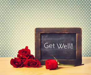 Get Well Text on Small Chalkboard with Red Roses