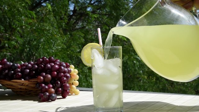 Pouring a glass of lemonade on the patio
