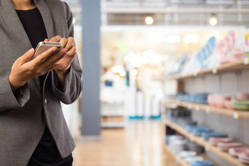 Fototapeta premium Women in shopping mall using mobile phone.